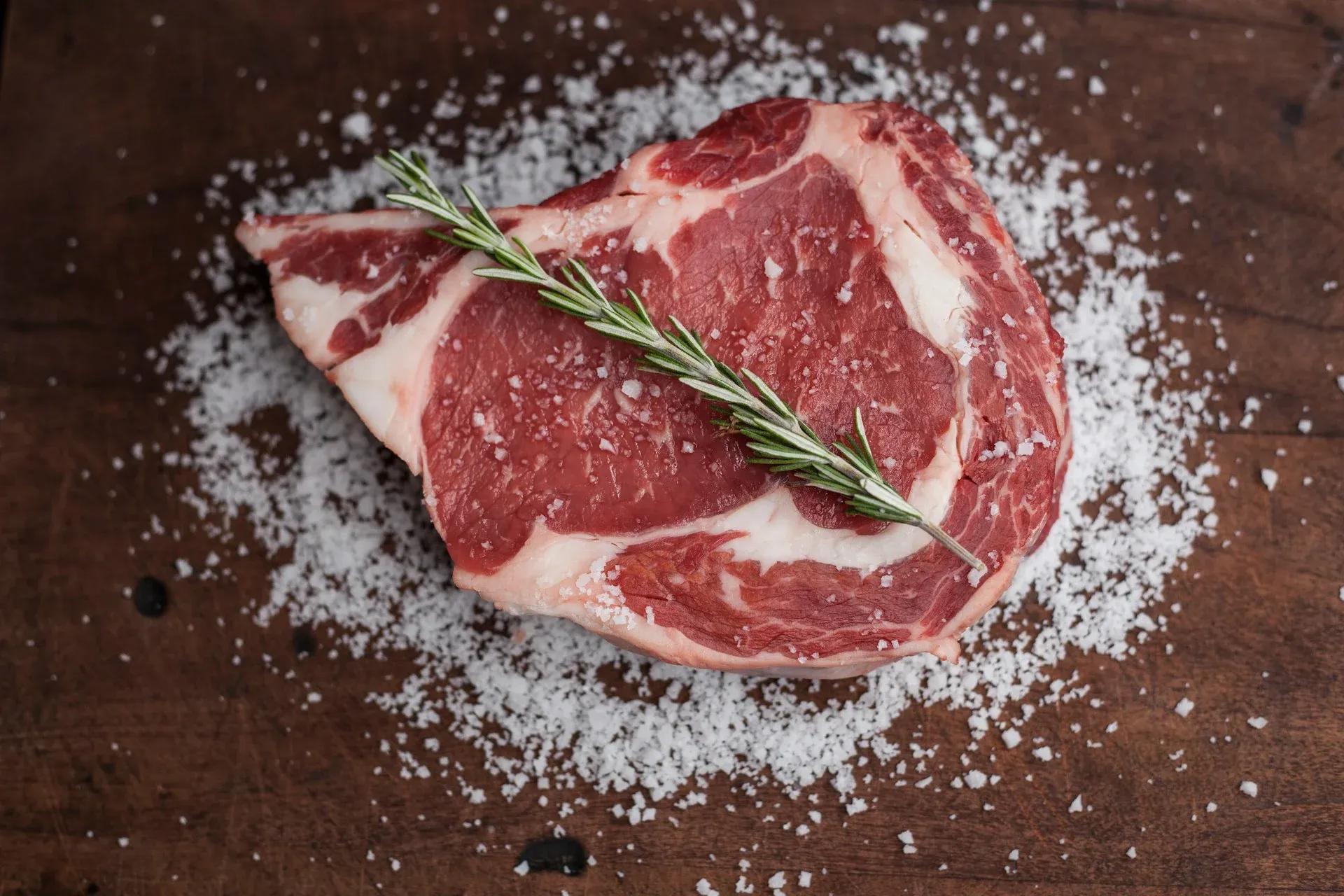 Raw cuts of meat on a wooden butcher table — H&M Custom Meat, Creston WA