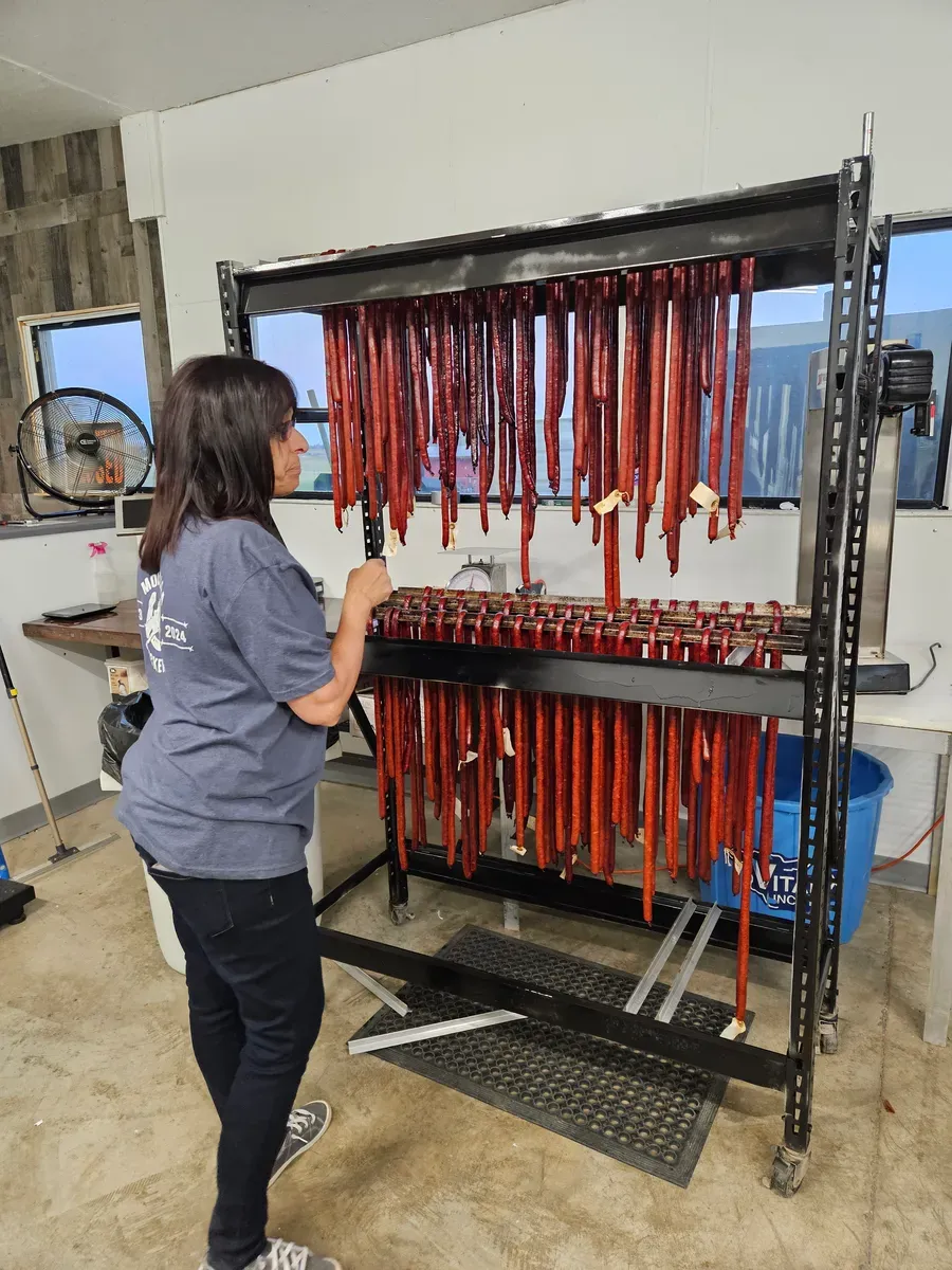 Smoked meat sticks hanging on racks at H&M Custom Meat
